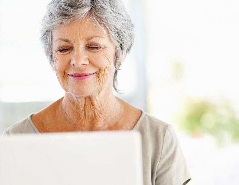 A woman using a laptop and smiling